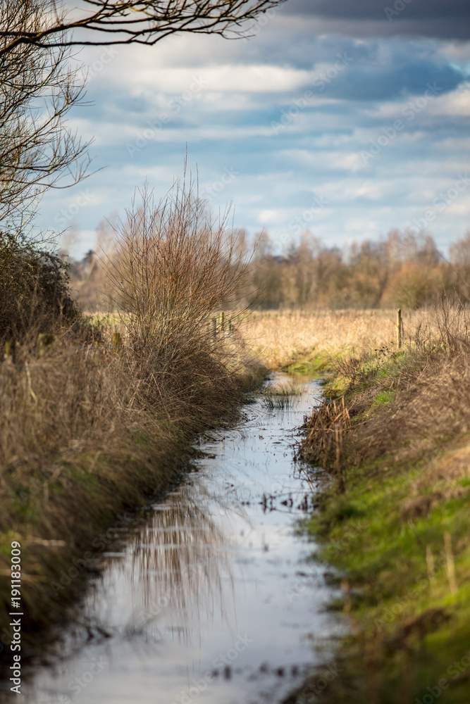 Dark clouds over a small stream in a wintery Wiltshire. Dark clouds over a small stream in a wintery Wiltshire.