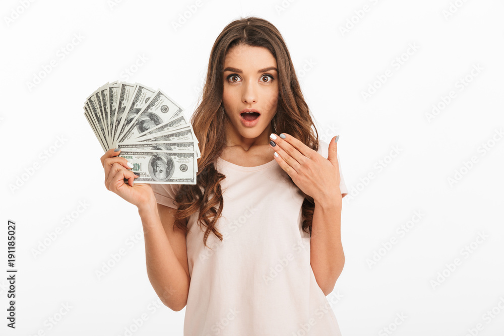 Surprised brunette woman in t-shirt holding money Surprised brunette woman in t-shirt holding money