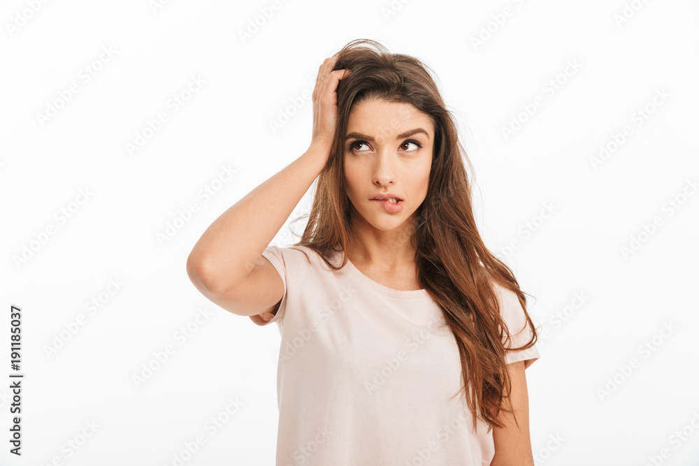 Pensive brunette woman in t-shirt holding head and looking away Pensive brunette woman in t-shirt holding head and looking away