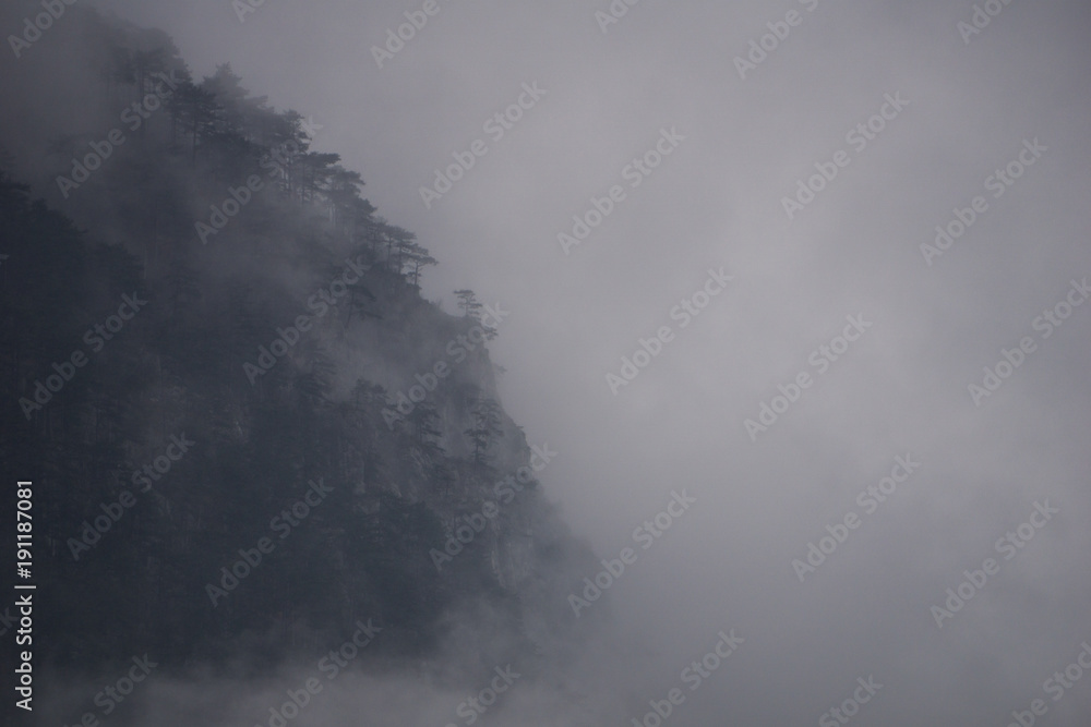 Heavy fog engulfing the rugged cliffs of the Cerna Mountains and their pine forests Heavy fog engulfing the rugged cliffs of the Cerna Mountains and their pine forests