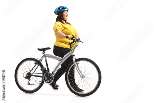 Fototapeta Naklejka Na Ścianę i Meble -  Overweight woman pushing a bicycle