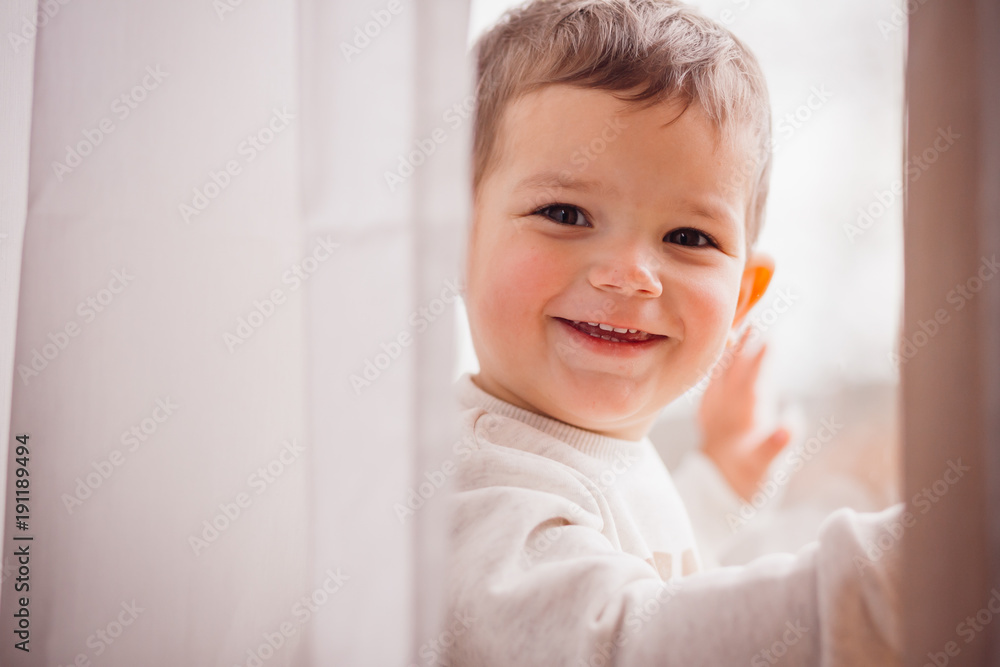 The beautiful boy stands near window The beautiful boy stands near window