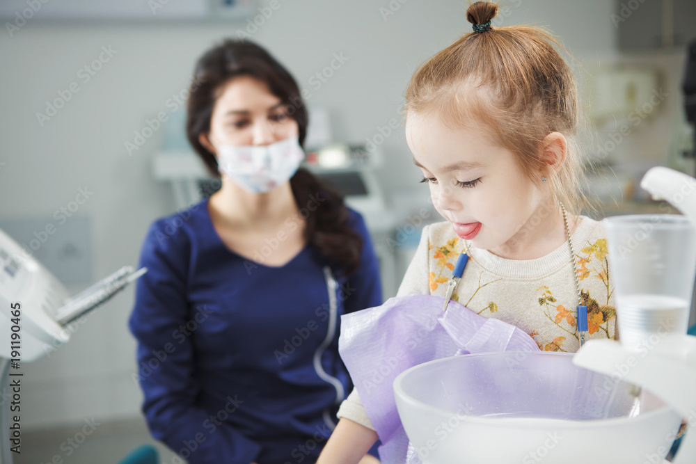 Child rinses out mouth and sits in dentist chair