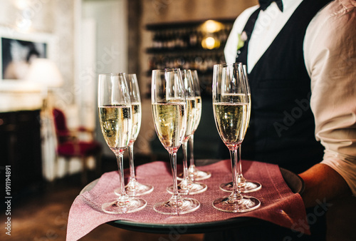 waiter brings glasses of champagne