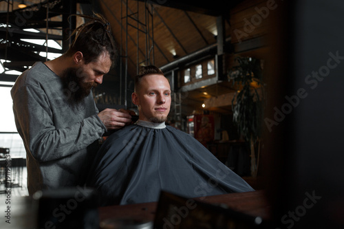 Barber cutting hair of customer. Smal business