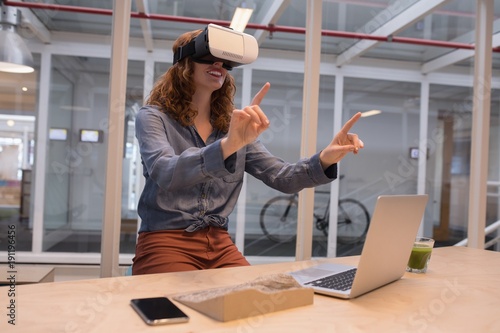 Female executive using virtual reality headset photo