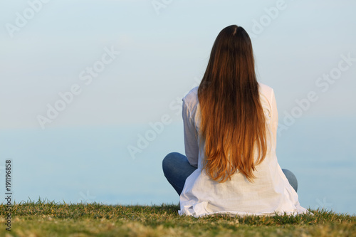 Wallpaper Mural Woman alone watching the sky sitting on the grass Torontodigital.ca