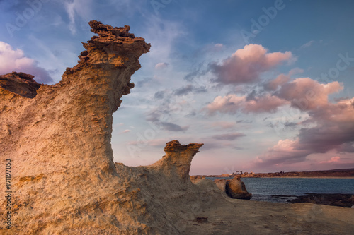 Beatiful Cyprus sunset on the desert empty rocky coast with strange fiqures at the Halk beach photo