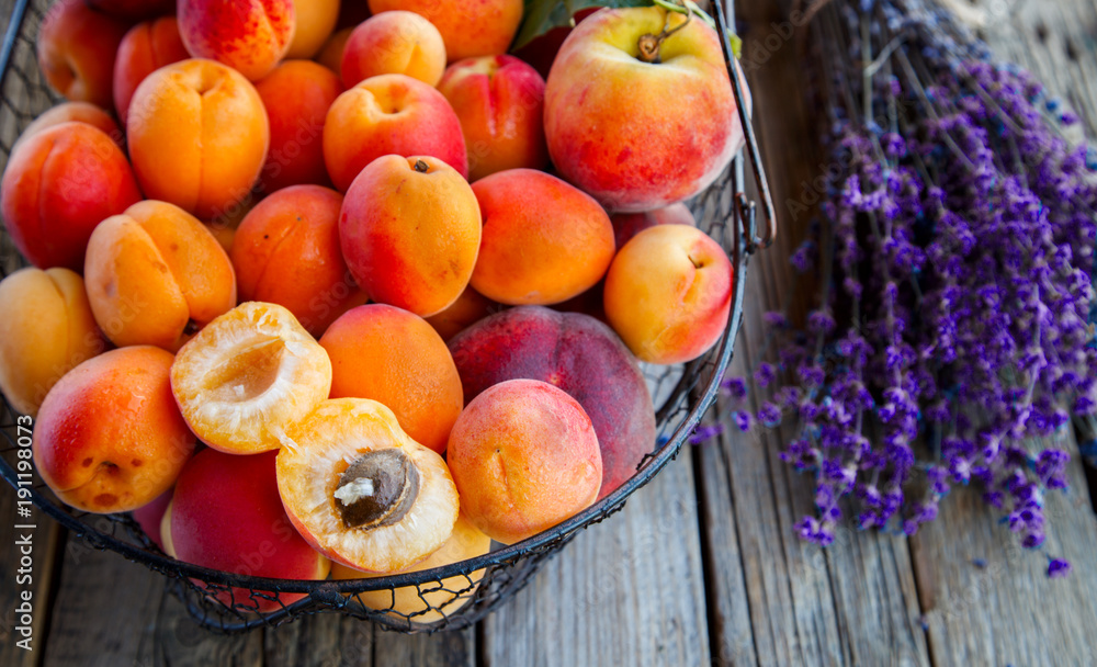 Apricots, Fruits in a metal basket on a vintage wooden background.Lavender, Flowers Bouquet.Food or Healthy diet concept.Super Food.Vegetarian.Copy space for Text.selective focus.