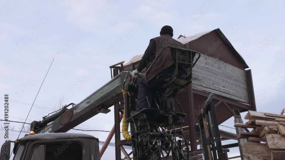 Lorry arm loader unloads timber scraps from heavy truck at sawmill facility, cold cloudy winter day Lorry arm loader unloads timber scraps from heavy truck at sawmill facility, cold cloudy winter day