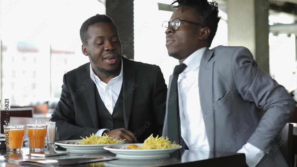 Young african friends businessmans in classical suits talks in cafe Young african friends businessmans in classical suits talks in cafe