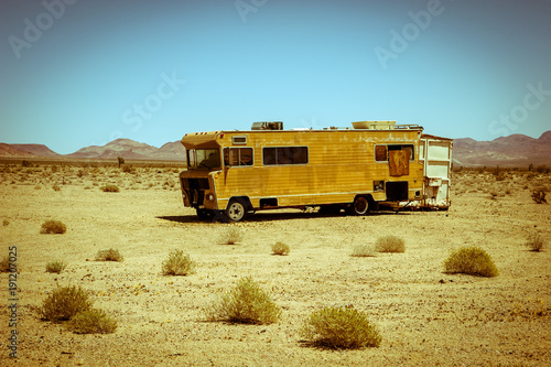 Abandoned RV camper van in the scenic landscape of the mojave desert, Vintage toned effect photo