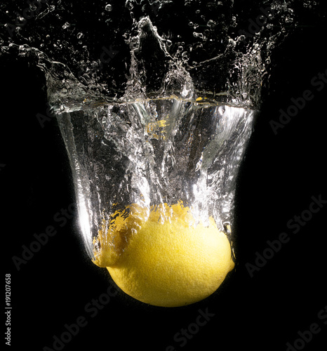 Yellow lemon in water on a black background