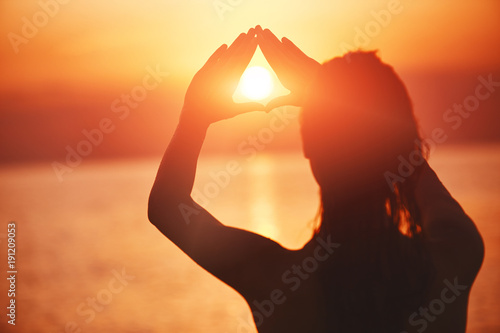 silhouette of a beautiful sexual girl against the sea and sunset. happy woman enjoying summer vacation
