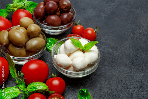 Traditional Italian products - Mozzarella cheese, basil, tomato and olives