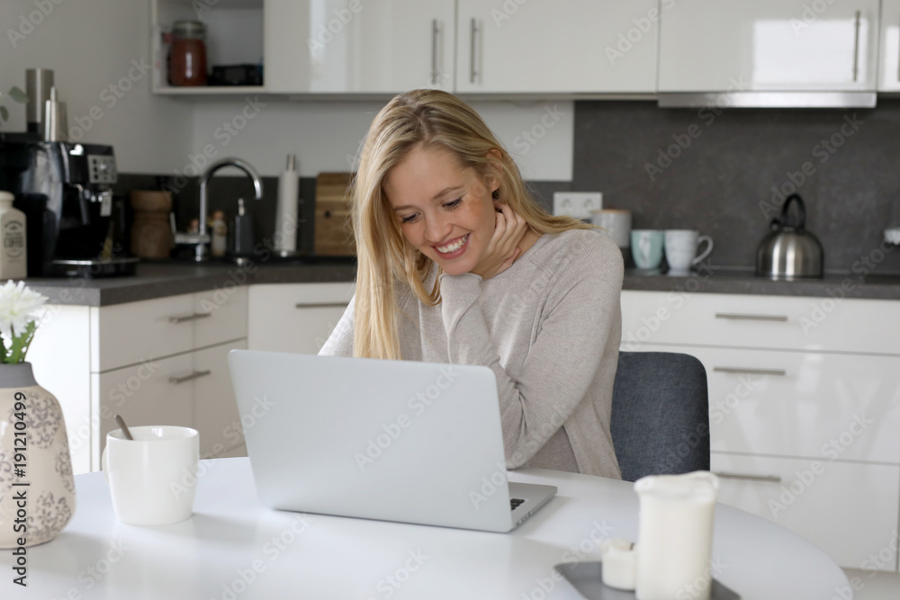 Hübsche blonde Frau mit Laptop freut sich Hübsche blonde Frau mit Laptop freut sich
