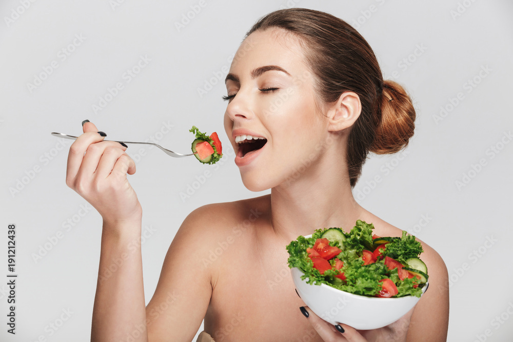 young woman eating healthy salad isolated on white young woman eating healthy salad isolated on white