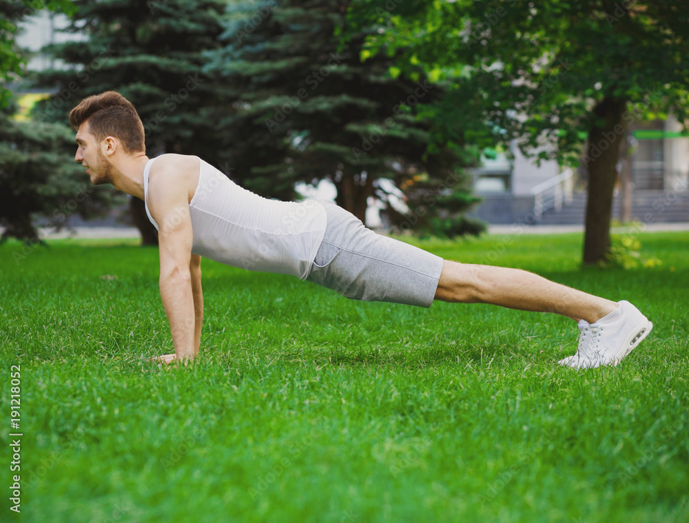 Fitness man plank training in park outdoors Fitness man plank training in park outdoors