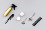 Professional tools for haircut. Sciccors, comb, spray on grey background top view copy space
