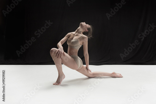 Young teen dancer on white floor background.