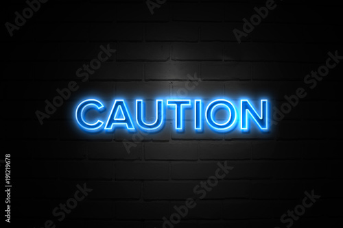 Caution neon Sign on brickwall