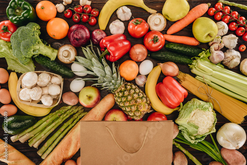 top view of shopping bag with vegetables and fruits on wooden table