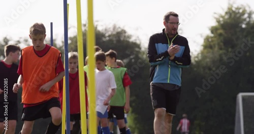 A Soccer coach is pleased with a young player and gives him a high five during training session.Shot on RED Epic photo