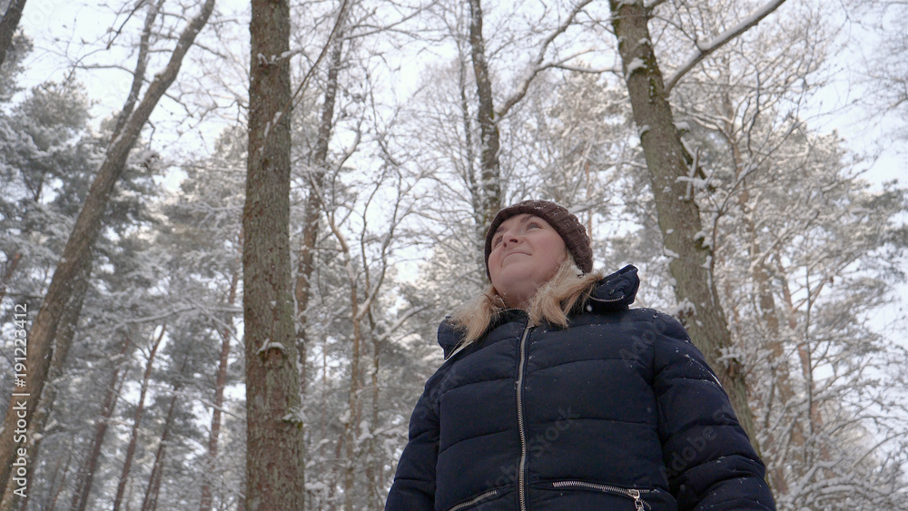 A beautiful girl (woman) walks through the forest, looks around, in winter, everything in white snow and trees. A beautiful girl (woman) walks through the forest, looks around, in winter, everything in white snow and trees.