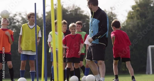 A Soccer coach is pleased with a young player and gives him a high five during training session.Shot on RED Epic photo