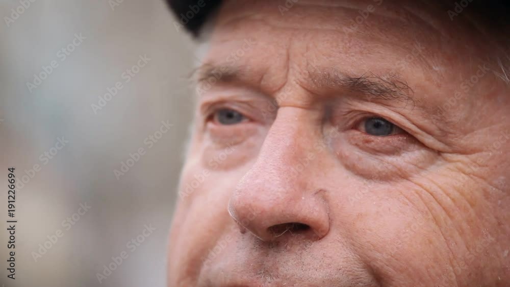 An impressive closeup of a senior man. His face is covered with deep wrinkles. He stands outdoors and reflects upon his life in autumn. An impressive closeup of a senior man. His face is covered with deep wrinkles. He stands outdoors and reflects upon his life in autumn.