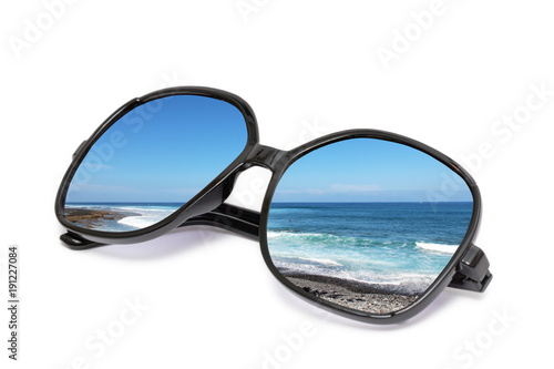 Sonnenbrille mit Strand Spiegelung freigestellt auf weißem Hintergrund