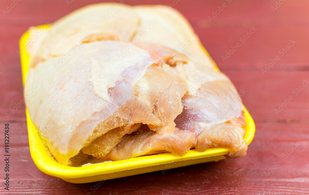 Raw chicken thighs in the tray.