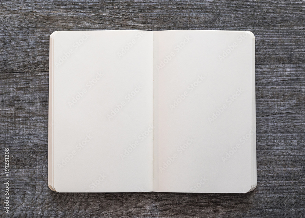 Fototapeta premium Blank open A5 size book, catalog, magazine, brochure, or booklet mock up template paper texture on brown wood table floor