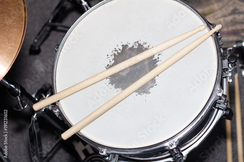 Drum with drumsticks as a musical background. Closeup image