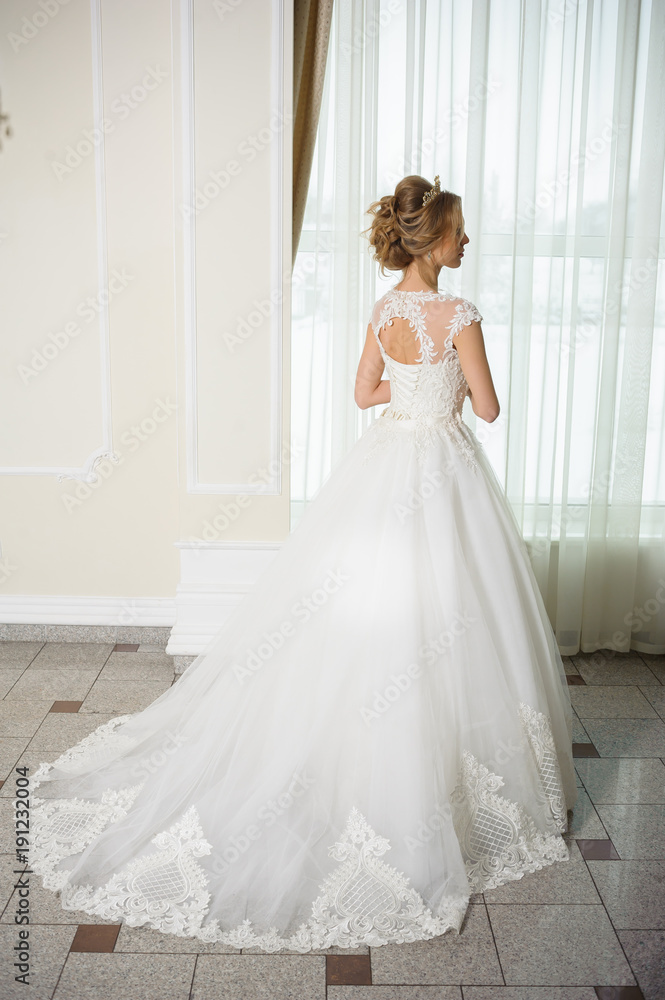 Beautiful bride in wedding dress before wedding ceremony in great hall