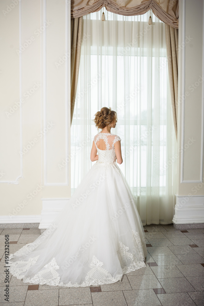 Beautiful bride in wedding dress before wedding ceremony in great hall Beautiful bride in wedding dress before wedding ceremony in great hall