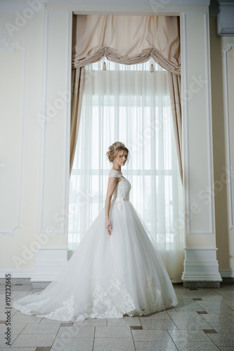 Beautiful bride in wedding dress before wedding ceremony in great hall