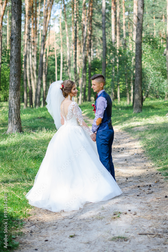 Bride and groom in a park kissing.couple newlyweds bride and groom at a wedding in nature green forest photo portrait.Wedding Couple