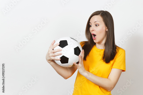 Beautiful European young cheerful happy woman, football fan or player in yellow uniform holding soccer ball isolated on white background. Sport, play football, health, healthy lifestyle concept. © ViDi Studio