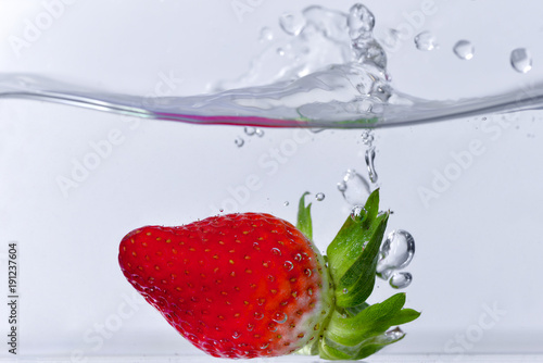 Strawberry in water on white background. 