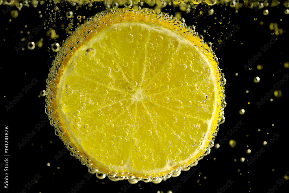Lemon slice in mineral water on the black background. Lemon slice in mineral water on the black background.