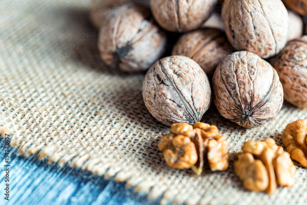 Walnuts and kernels on burlap on wooden backgound Walnuts and kernels on burlap on wooden backgound