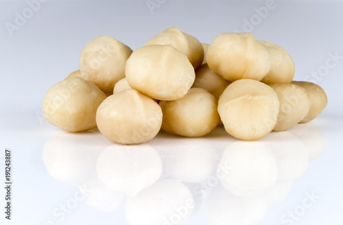 A handful of kernels of macadamia nuts on a light background.