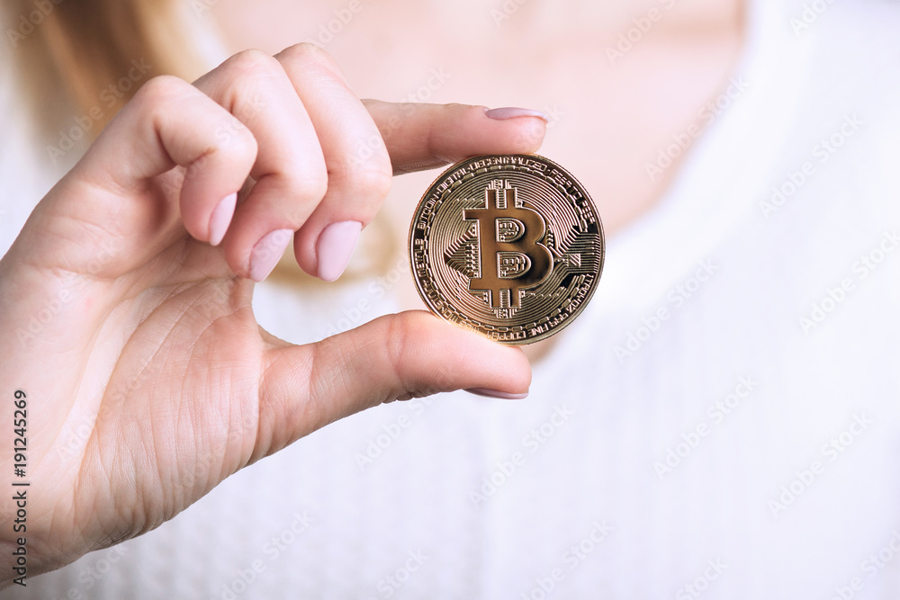 golden bitcoin in a woman hand, symbol of a crypto-currency, golden bitcoin in a woman hand, symbol of a crypto-currency,