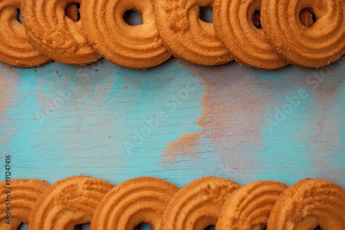 Pattern of butter cookies/biscuits on wooden teal green rustic background with space for text, flat lay design with butter cookies photo