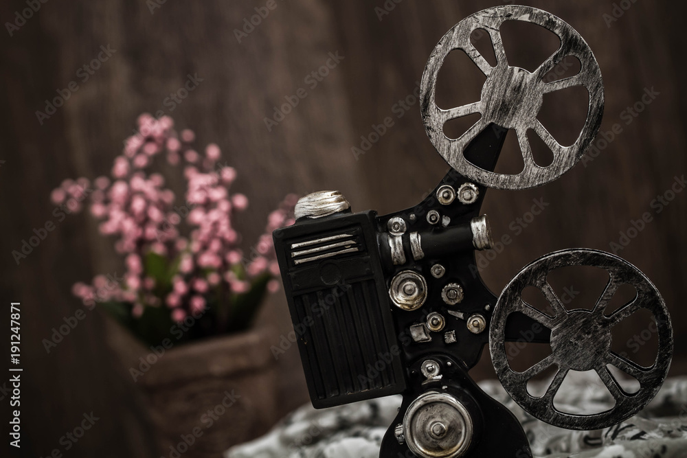 Fototapeta premium Small nostalgic decorative film camera on brown wooden background