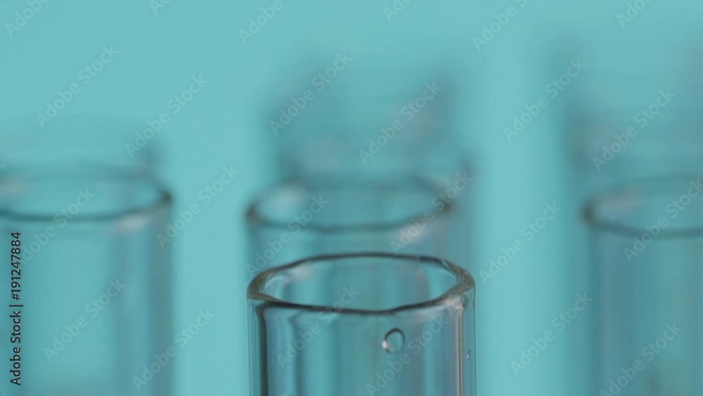 Close up of laboratory scientist working with a pipette analyzes and extract the DNA or molecules in the test tubes.on blue background Close up of laboratory scientist working with a pipette analyzes and extract the DNA or molecules in the test tubes.on blue background