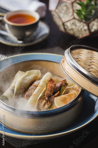 Pancakes with peking duck and hoisin sauce on the basket. Dry ice. Russian Maslenitsa.