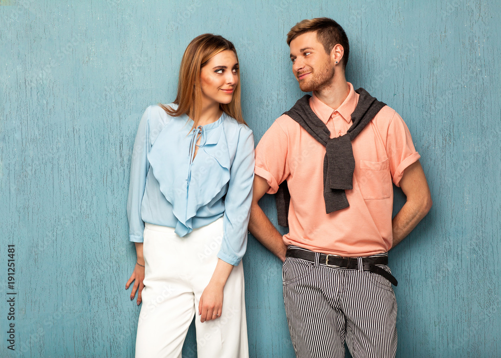 Fashion girl and guy in outlet clothes posing on a blue background. Valentines Day.