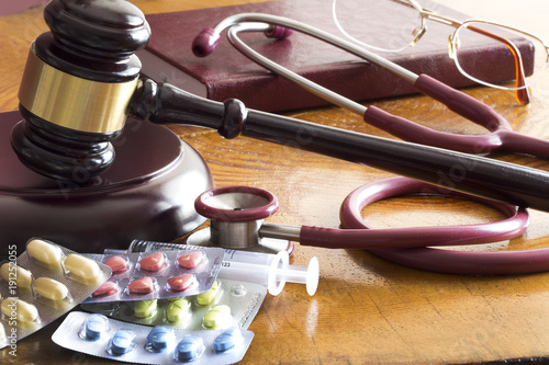 Drug law concept. Judges gavel with  stethoscope  and pills close up